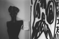 a black and white photo of a mannequin with graffiti on it